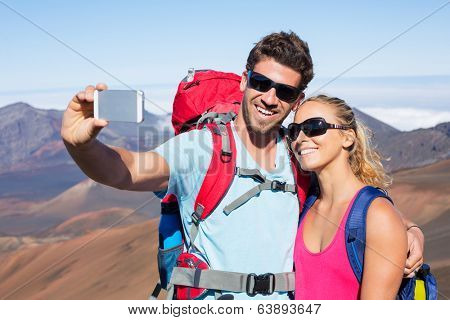 Happy couple taking photo of themselves with smart phone outdoors, Taking a 