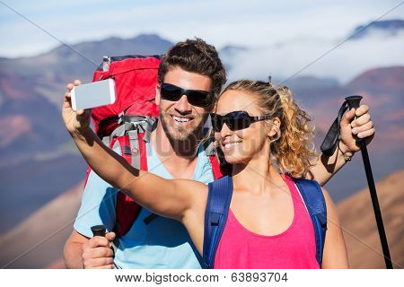 Happy couple taking photo of themselves with smart phone outdoors, Taking a 