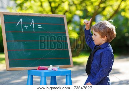 Little Boy At Blackboard Practicing Mathematics