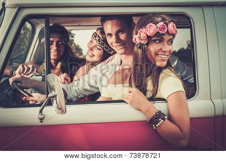 Multi-ethnic hippie friends in a minivan on a road trip