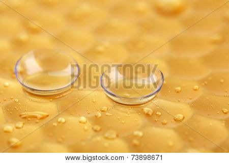 Contact lenses with water drops on bright background