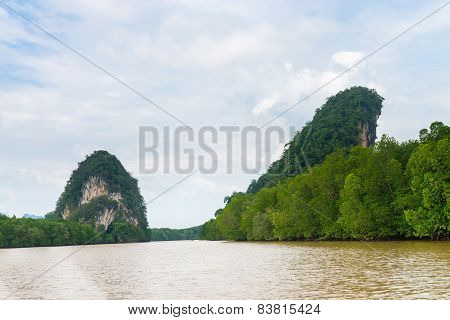 Two Limestone Cliffs Above Tropical River And Mangrove