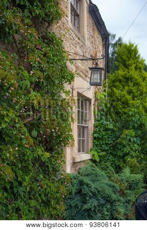 CHIPPENHAM, UK - AUGUST 9, 2014: Castle Combe, unique old English village. Old house and park