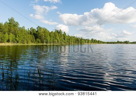 White Clouds On The Blue Sky Over Blue Lake