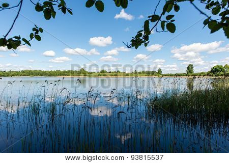 White Clouds On The Blue Sky Over Blue Lake