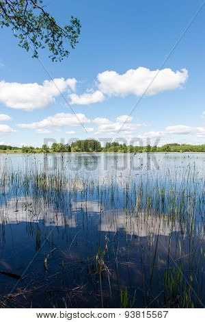 White Clouds On The Blue Sky Over Blue Lake