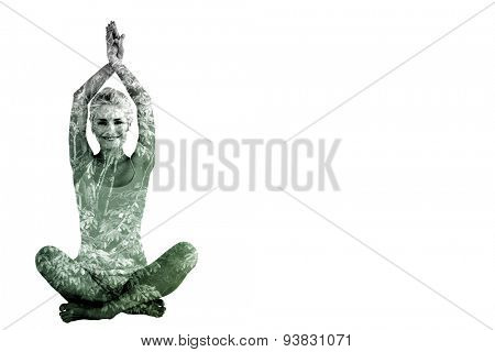 Sporty woman sitting in Namaskar pose with twisted hands against beautiful pink leaved trees