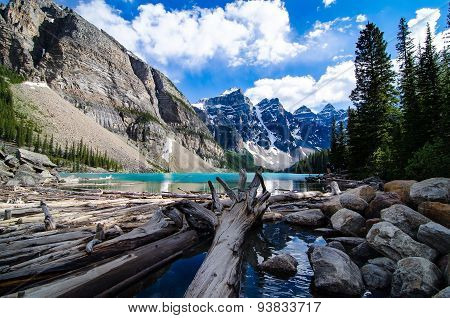 A view of the valley of ten peaks and moraine lake from a low wide angle in summer with blue skies and clouds.