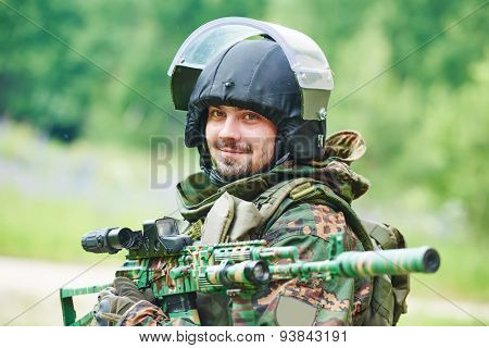military. portrait of soldier in uniform with assault rifle outdoors