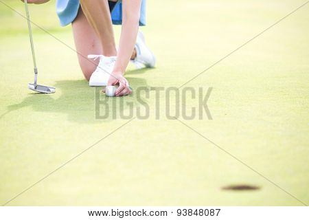 Low section of woman placing ball at golf course