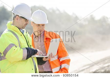 Supervisors using laptop at construction site