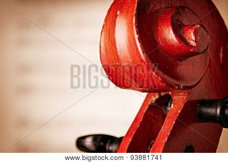 Close Up Of Violin Scroll In Front Of Sheet Music