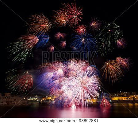 Red pink colorful fireworks explode in Malta in dark sky,Malta fireworks festival,Independence