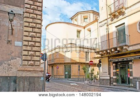 CATANIA ITALY - OCTOBER 10 2012: The view on the apse of Collegiate Church of Santa Maria dell'Elemosina surrounded by historic buildings and streets on October 10 in Catania.