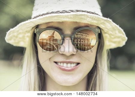 Woman in sunglasses and hat with traval images.