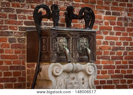 Old fountain near the brick wall in Grand Beguinage in Leuven. Belgium. Flanders.