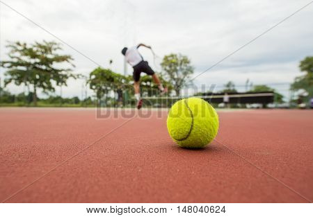 Tennis Ball on the Court Close up with the Net in the background