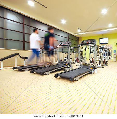 Hombre corriendo en la cinta de correr en el gimnasio