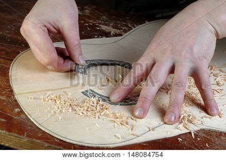 Luthier makes installation rosette classical guitar with the help of circular knives and gouges