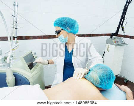 Laser Treatment. Caucasian Doctor Making Procedure Skin Nevus Removal To Woman Patient
