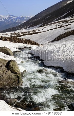 Mountain River With Snow Bridges In Spring Sun Day