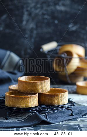 Stack of empty tartlets on dark background