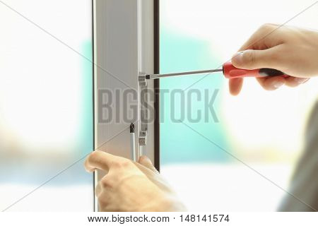 Construction worker installing window in house
