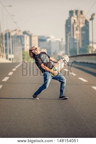 Happy Skateboarder On The Bridge Playing Guitar On His Skate Board