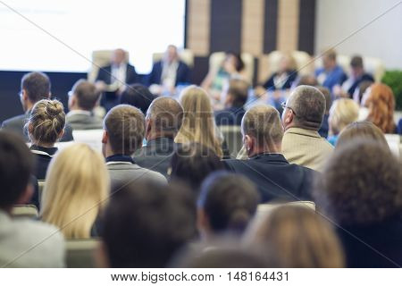 Group of Professionals At the Round table During the Conference. Speaking in Front of Large Group of People. Horizontal Image Composition