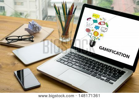 GAMIFICATION Laptop on table. Warm tone businessman working