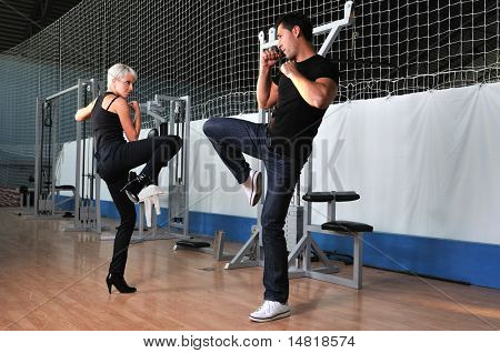 femme dans la gim de remise en forme avec coach personal trainer