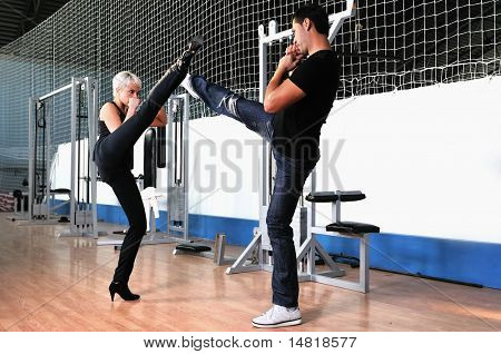 femme dans la gim de remise en forme avec coach personal trainer