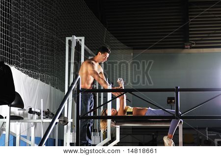 femme dans la gim de remise en forme avec coach personal trainer