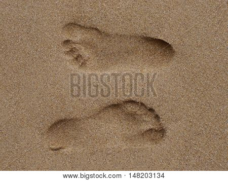 Two Footprints in sand at the Beach
