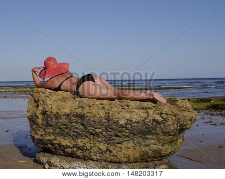 Beautiful Female  on stone against the ocean in Portugal