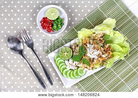 Fried rice with crab topped streamed crab,halve green lemon,sliced cucumber,lettuce and coriander  served  spicy  sour filling side dish.  Top view
