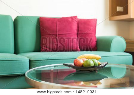 Fresh fruit and green sofa with red backrest pillow in living room