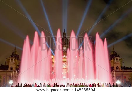 BARCELONA - SEPTEMBER 19, 2014: Night view of Magic Fountain light show in Barcelona, Catalonia, Spain. Magic fountain of Montjuic light show at Plaza Espanya in Barcelona with people silhouette on bottom.