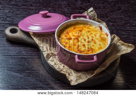 creamy casserole in a purple pot on the board