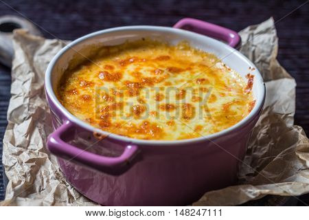 creamy casserole in a purple pot on the board