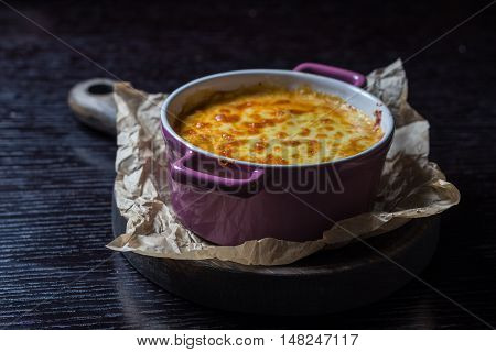 creamy casserole in a purple pot on the board