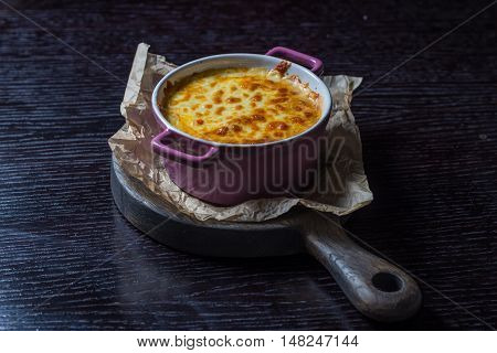 creamy casserole in a purple pot on the board