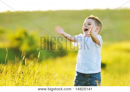 heureux jeune bel enfant Amusez-vous sur pouve avec jouet de bulles de savon