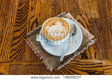 Cup of cappuccino coffee on a wooden table