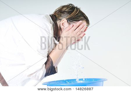 bautiful young woman wash face with clean water isolated on white in studio