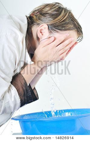 bautiful young woman wash face with clean water isolated on white in studio