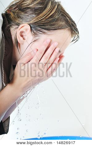 bautiful young woman wash face with clean water isolated on white in studio