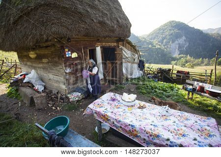 Salciua, Romania - September 14, 2016: Old rural woman selling cheese at the farm in the mountains