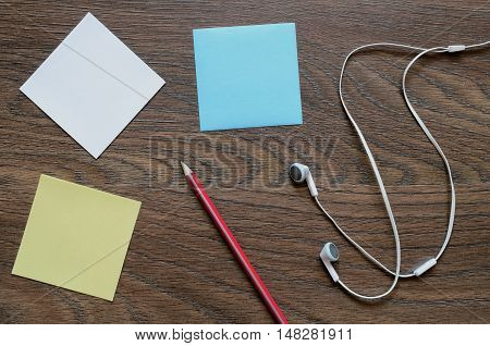 White Headphone, Paper And Pencil On Wooden Table