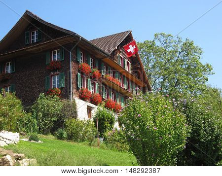 Traditional wooden Swiss House with a flag